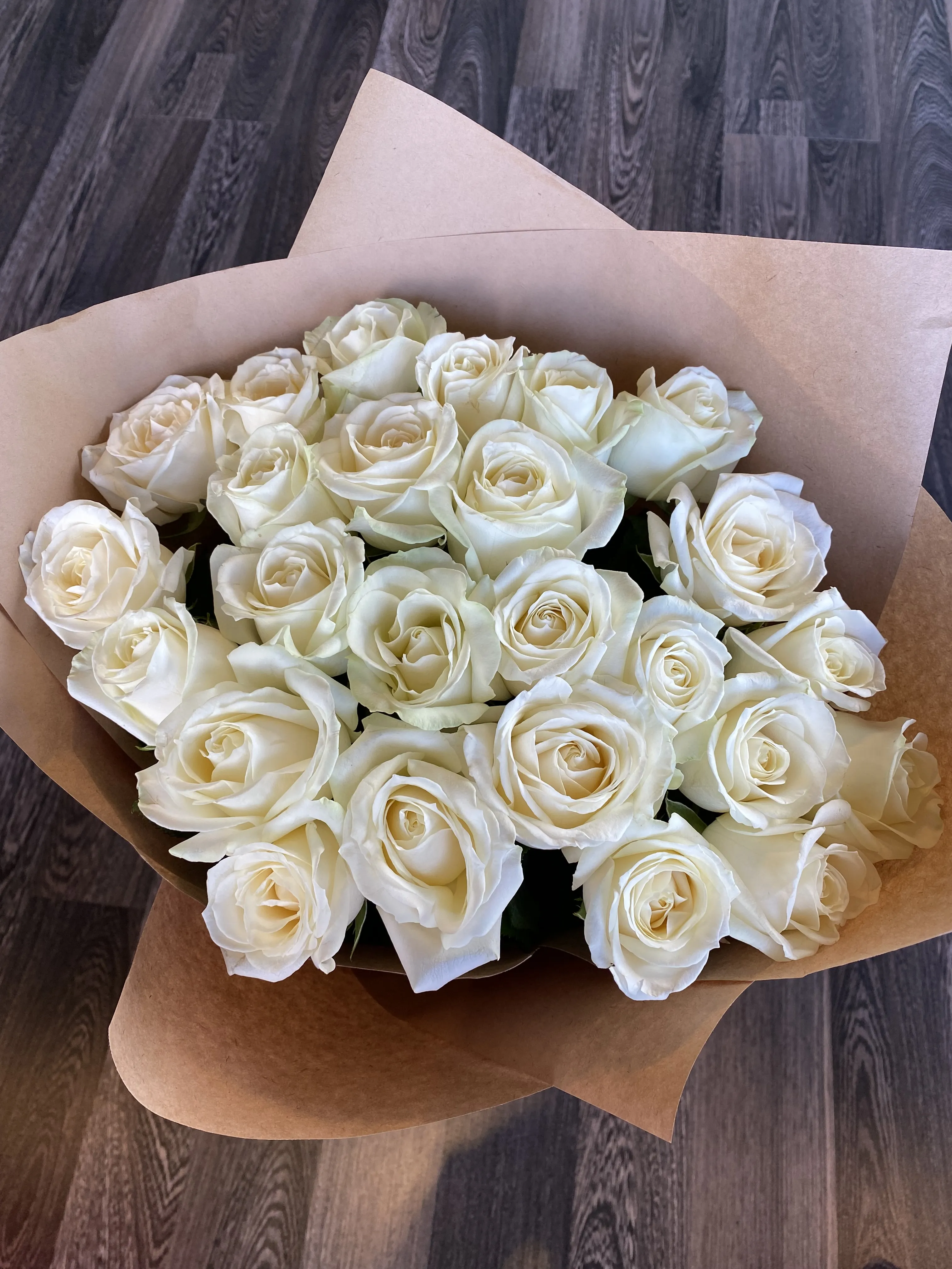 Фото Букет из 25 белых роз в крафте
